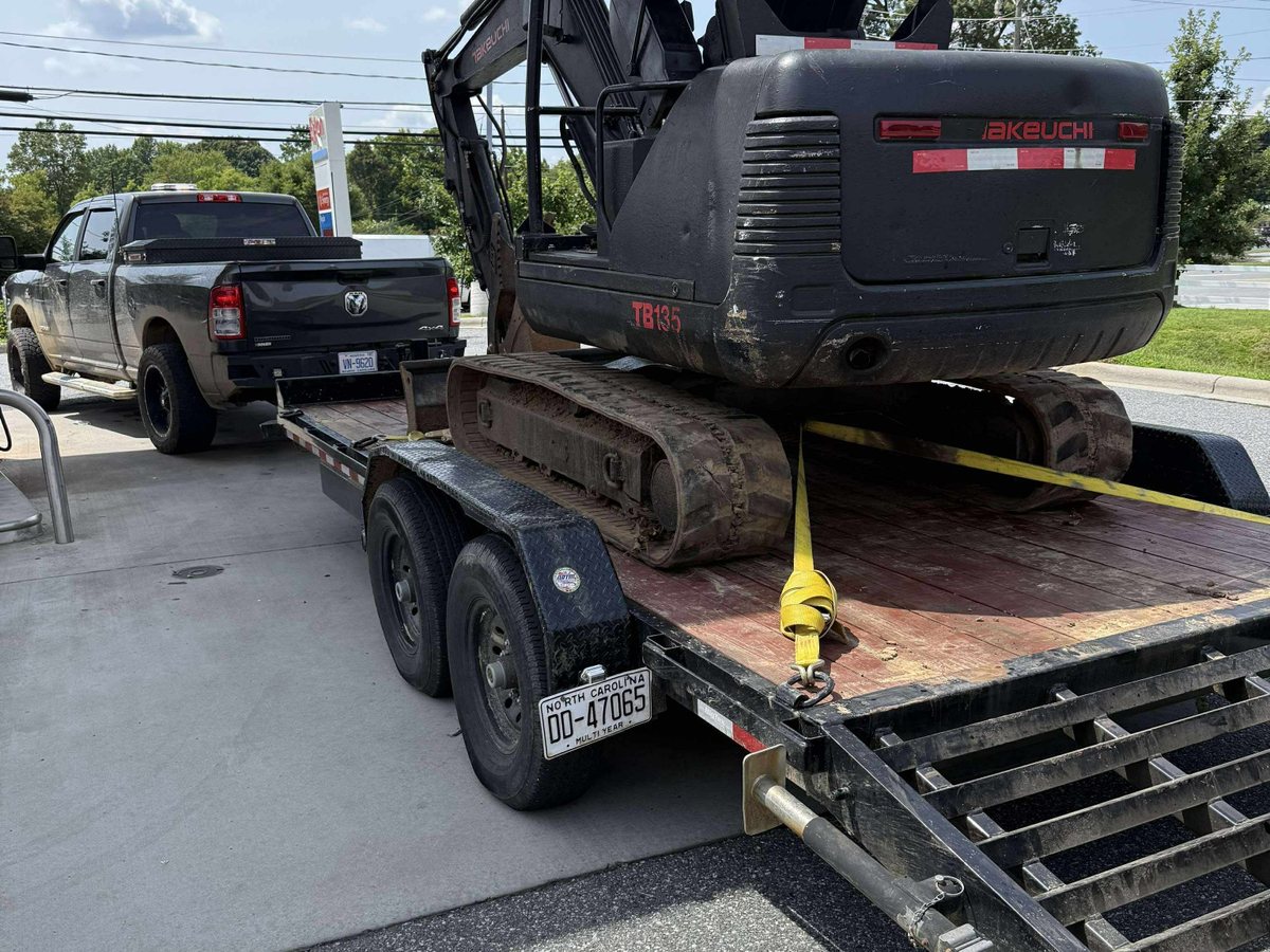 Mini excavator loaded on a trailer for transport