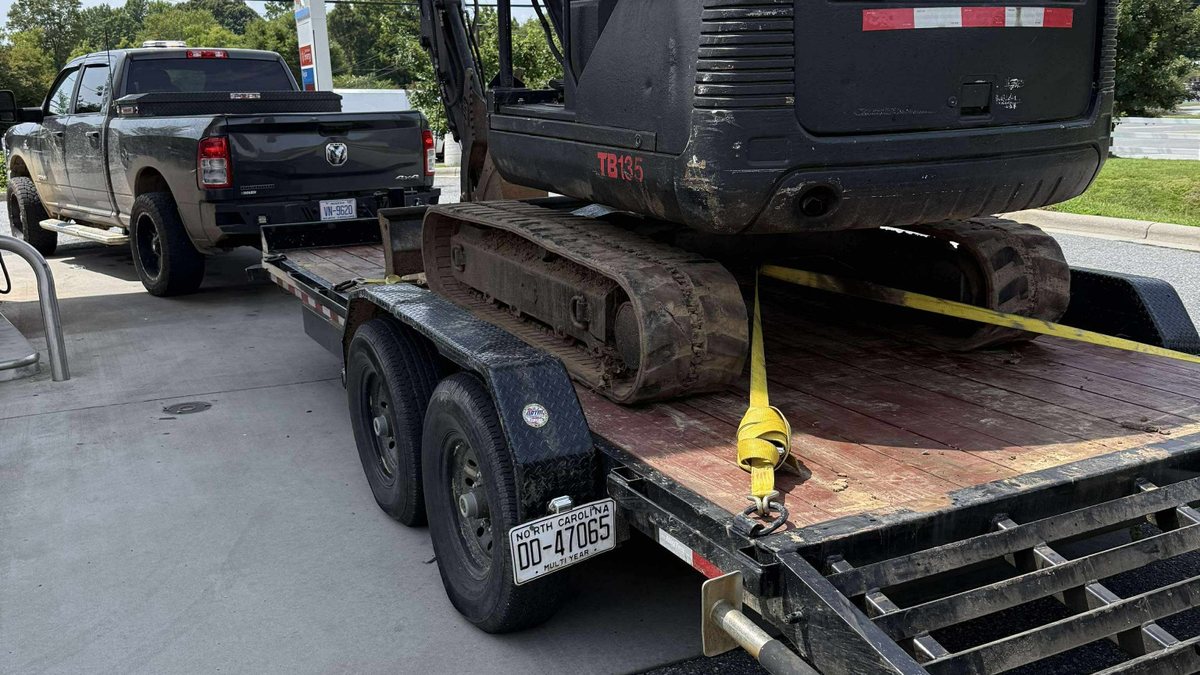 Mini excavator secured on a trailer for transport